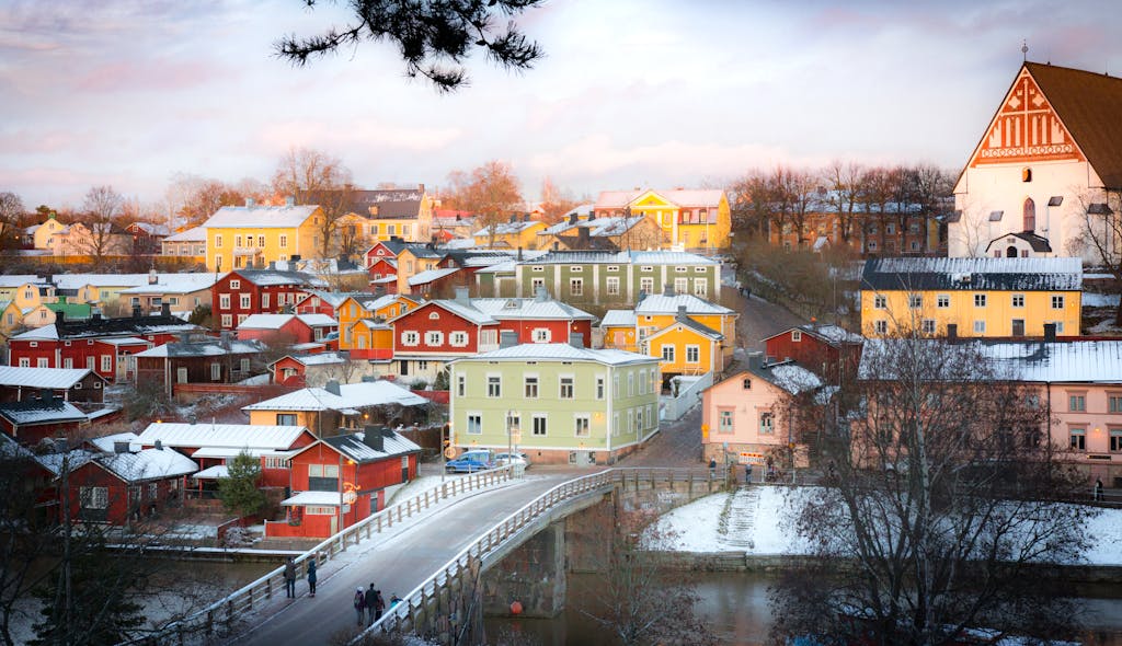 Captivating winter scene of colorful houses in Porvoo, Finland viewed from a bridge.