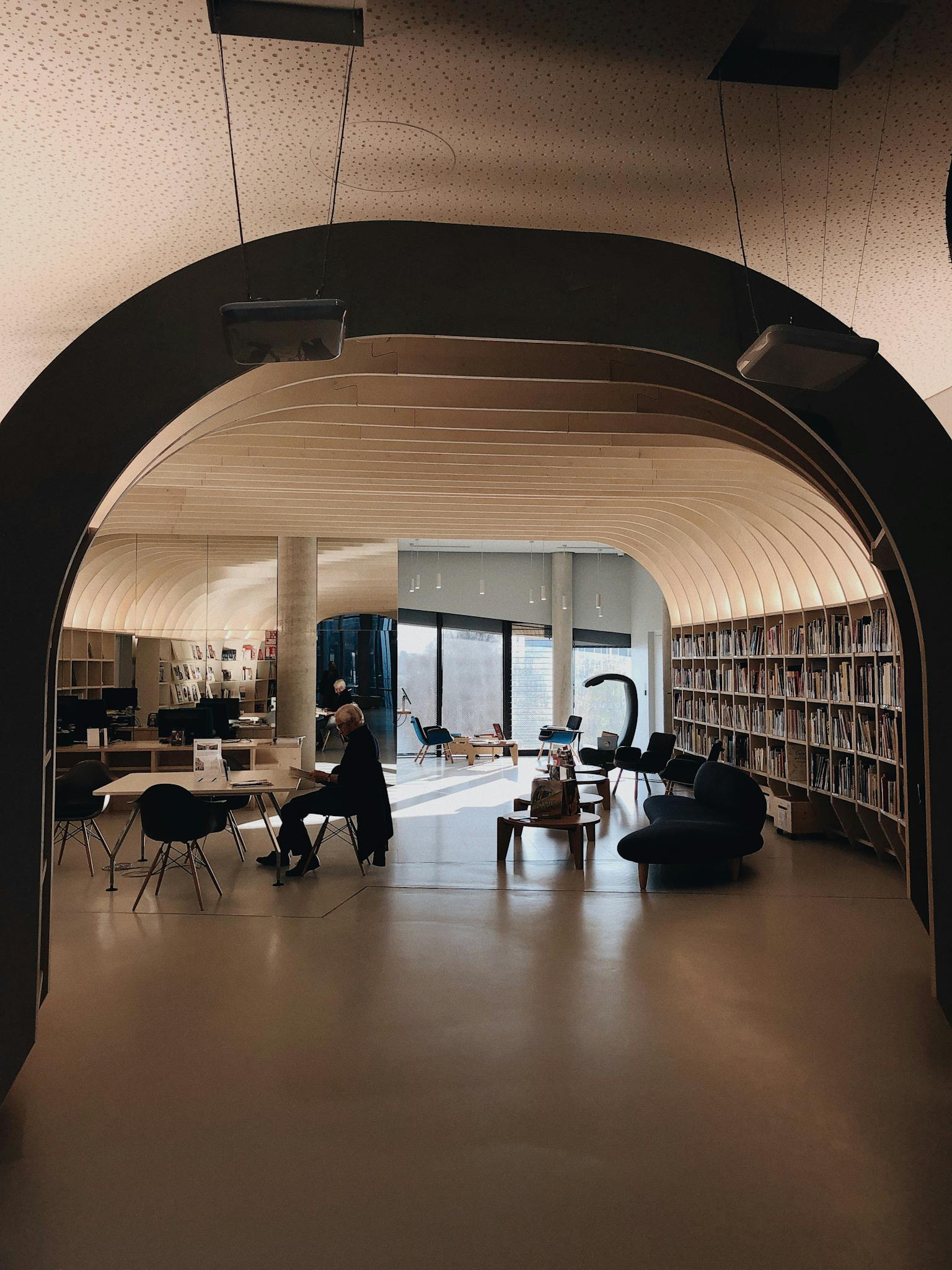 A modern library in Bordeaux with archways and sleek furniture, perfect for studying.